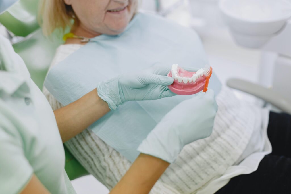 woman smiling while looking at dentures