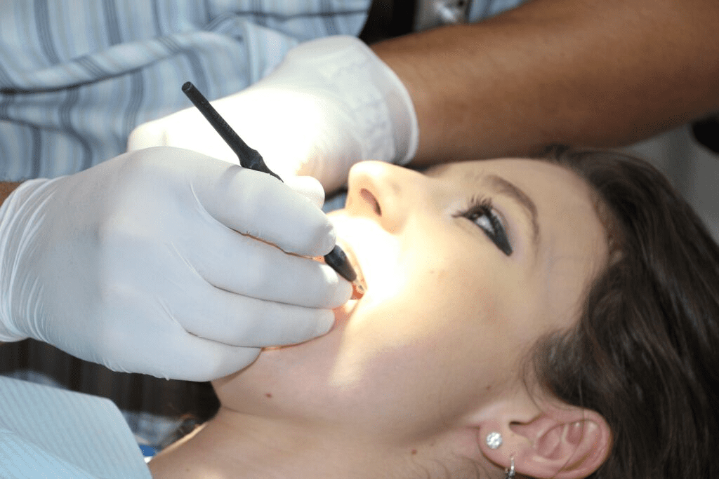 dentist looking inside woman’s mouth