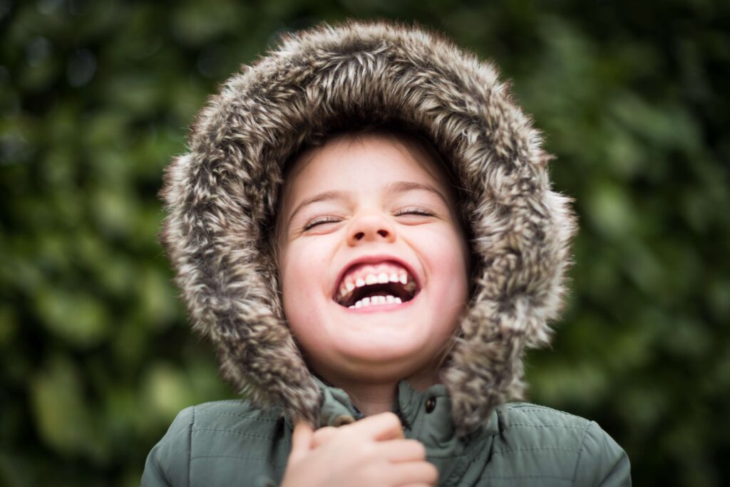 Child smiling in fur hood