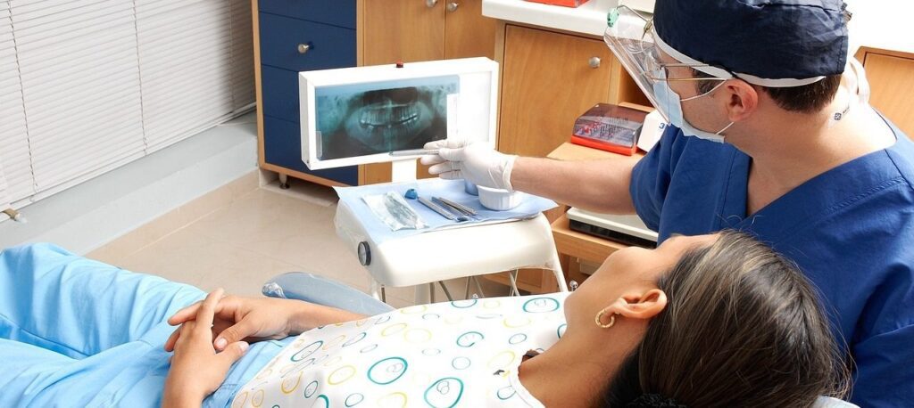 woman in dental chair looking at x-rays