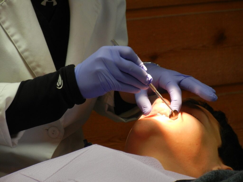 dentist with purple gloves examining a patient